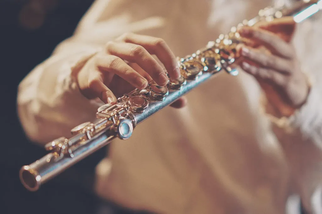 Photo of a close up of a person playing a flute