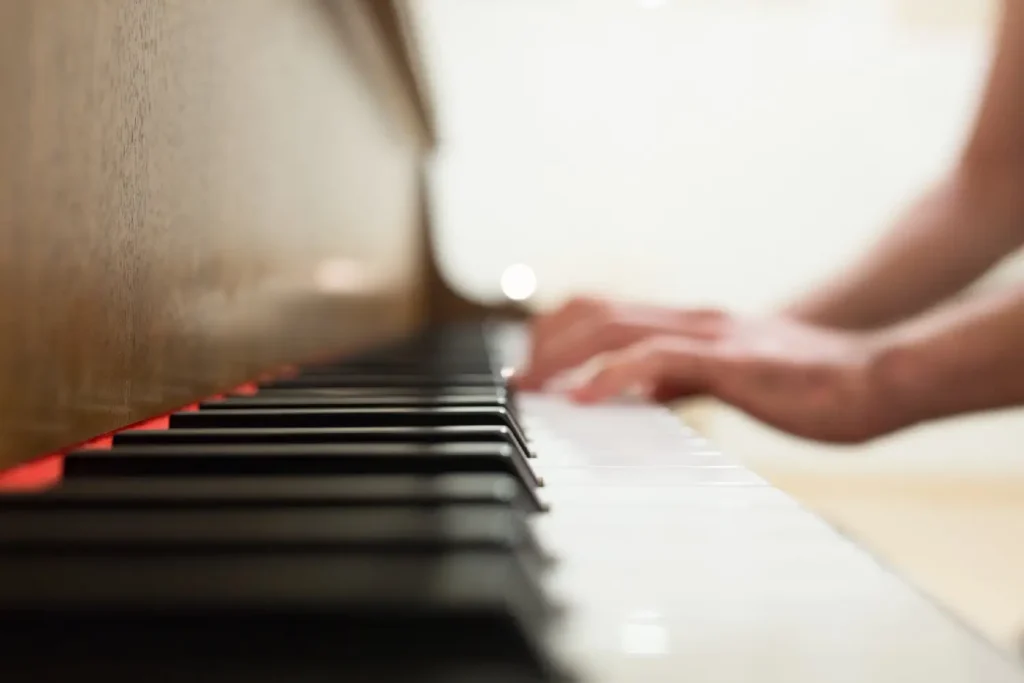 Close up photo of piano keys being played by out of focus hands